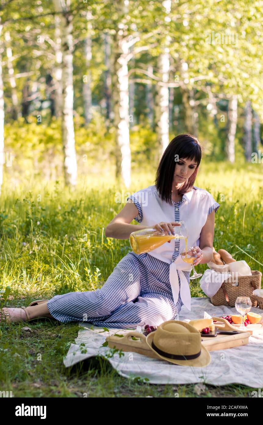 Attractive young woman at summertime park outdoor. Healthy food, relaxing  concept Stock Photo