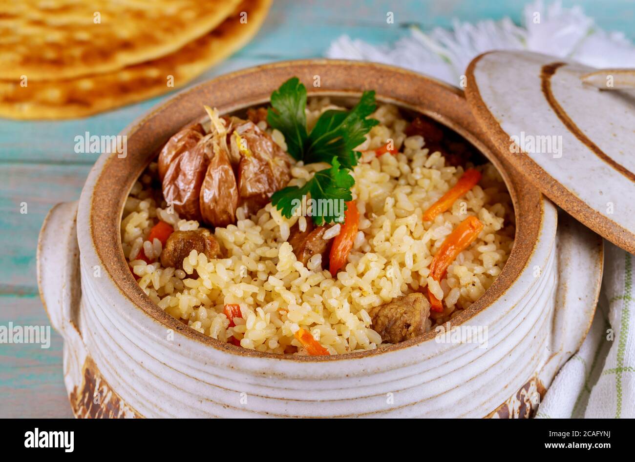 Turkish rice with vegetable and meat in pot with lid and flatbread on ...