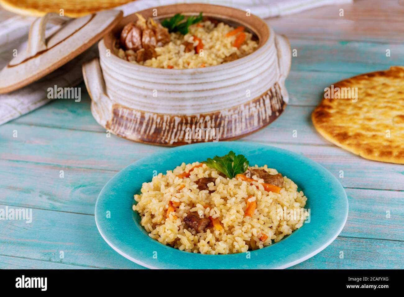 Delicious indian lunch with stewed rice ,meat and carrot in plate with flatbread. Stock Photo