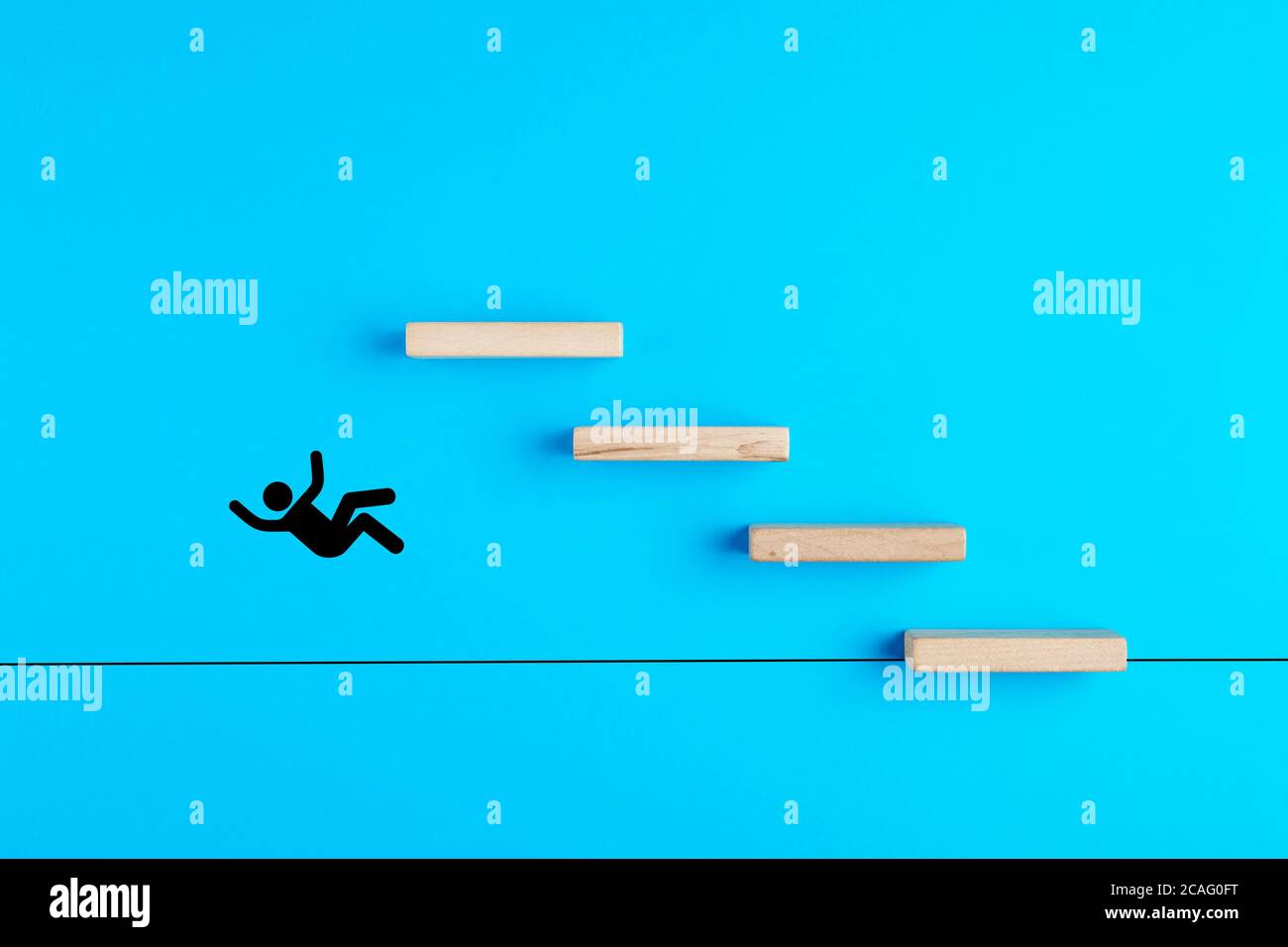 Stickman is falling down from the wooden stairs on blue background. Failure, downfall or stepping off the top in business concept. Stock Photo
