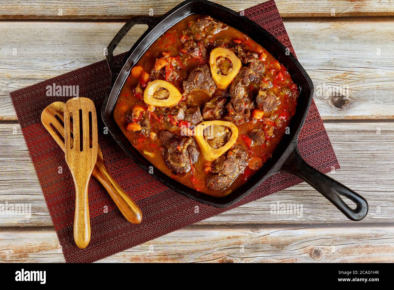 Cooked beef shank with vegetable and wine in cast iron. Ossobuco