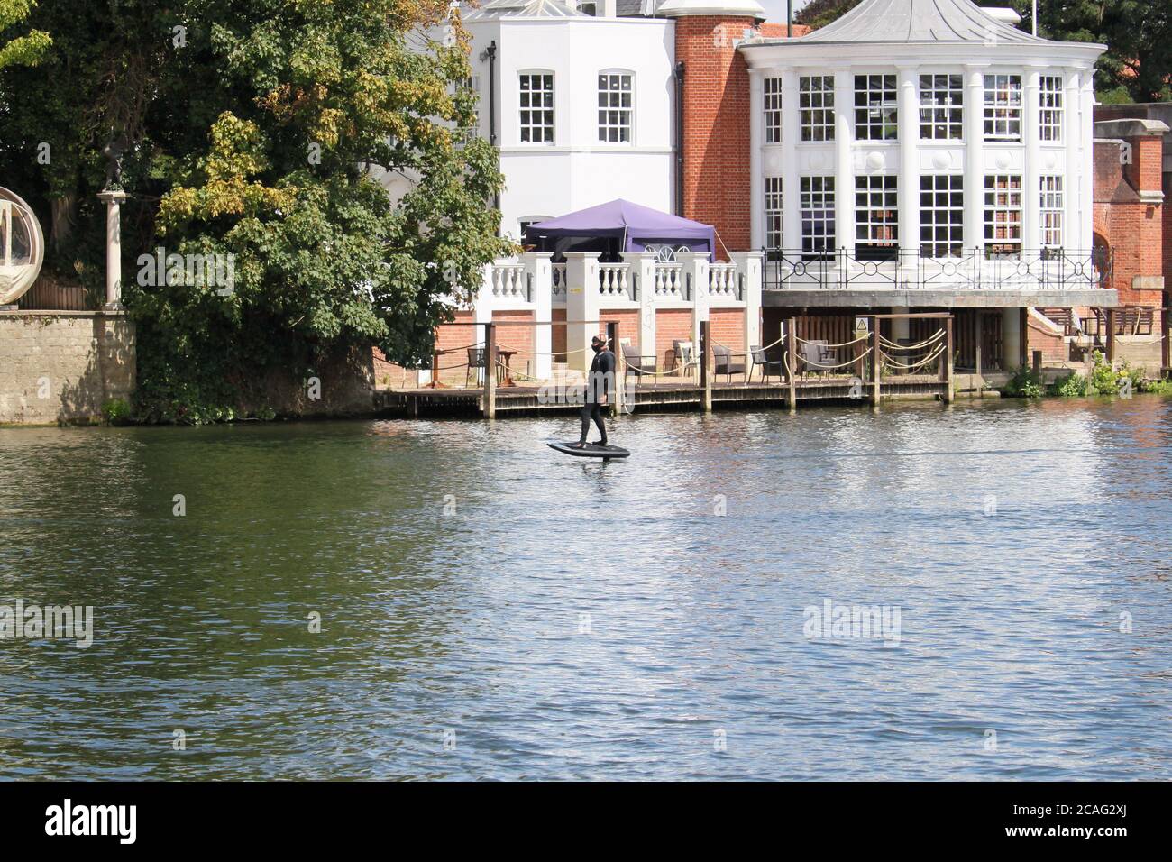 Man riding a personal hydrofoil (Lift eFoil), Mitre Hotel, River Thames, Hampton Court, Greater London, England, United Kingdom, UK, Europe Stock Photo