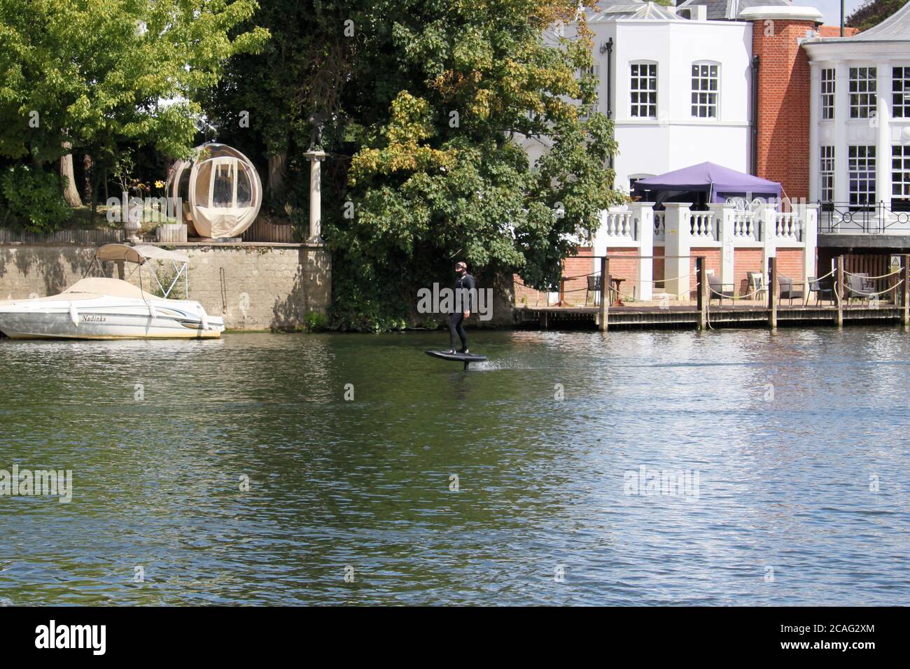 Man riding a personal hydrofoil (Lift eFoil), Mitre Hotel, River Thames, Hampton Court, Greater London, England, United Kingdom, UK, Europe Stock Photo