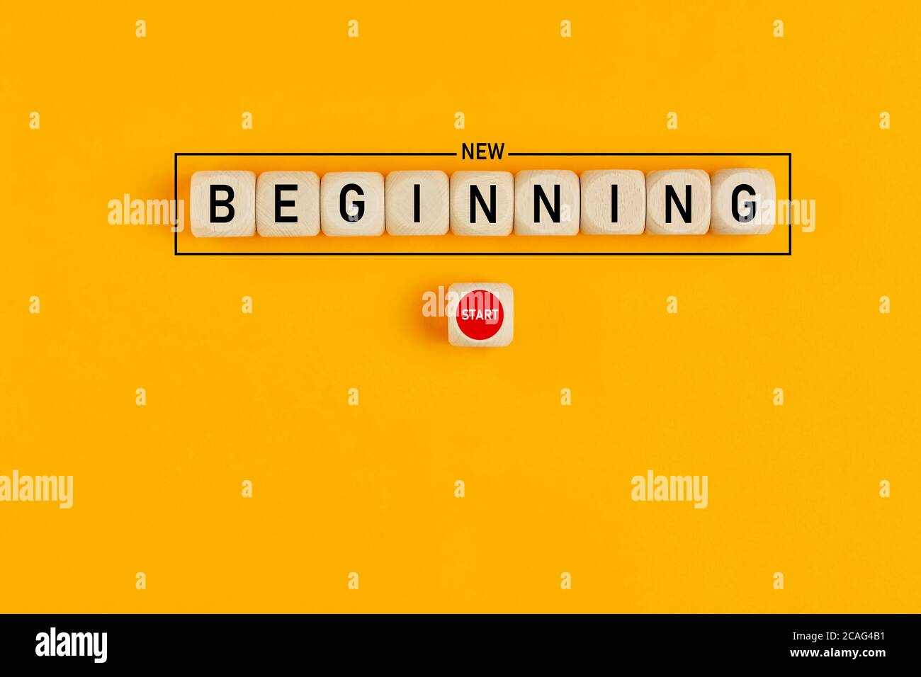 Starting a new beginning concept. The word new beginning on wooden cubes with a start button on yellow background. Stock Photo