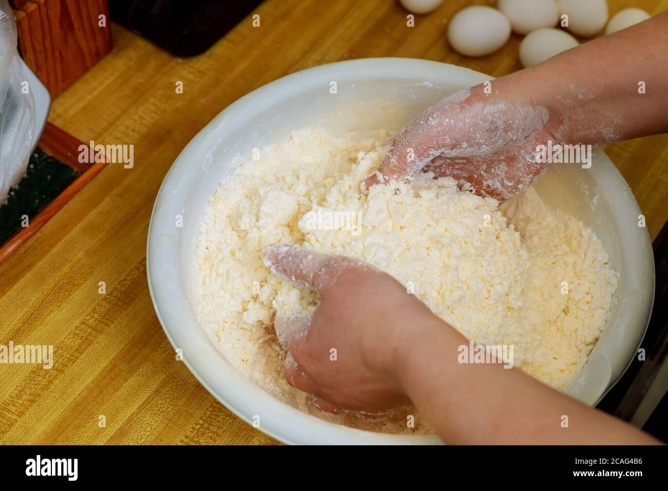 Woman mixing flour and cheese for making cheese bread dough. Cuisine of Paraguay. Stock Photo