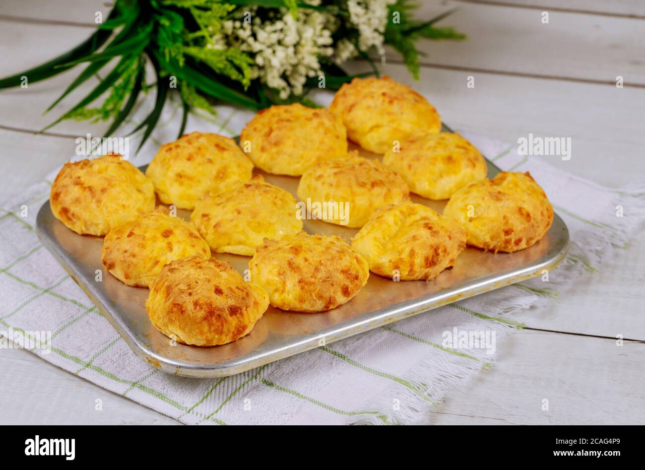 Cooked brazilian cheese bread chipa in baking pan with spoon. Stock Photo