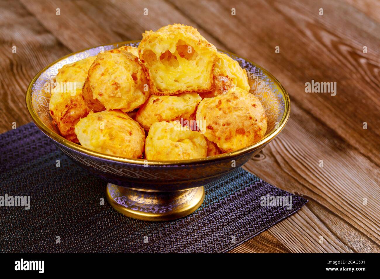 Chewy cheese bread called chipa on wooden table. Brazilian cuisine. Stock Photo