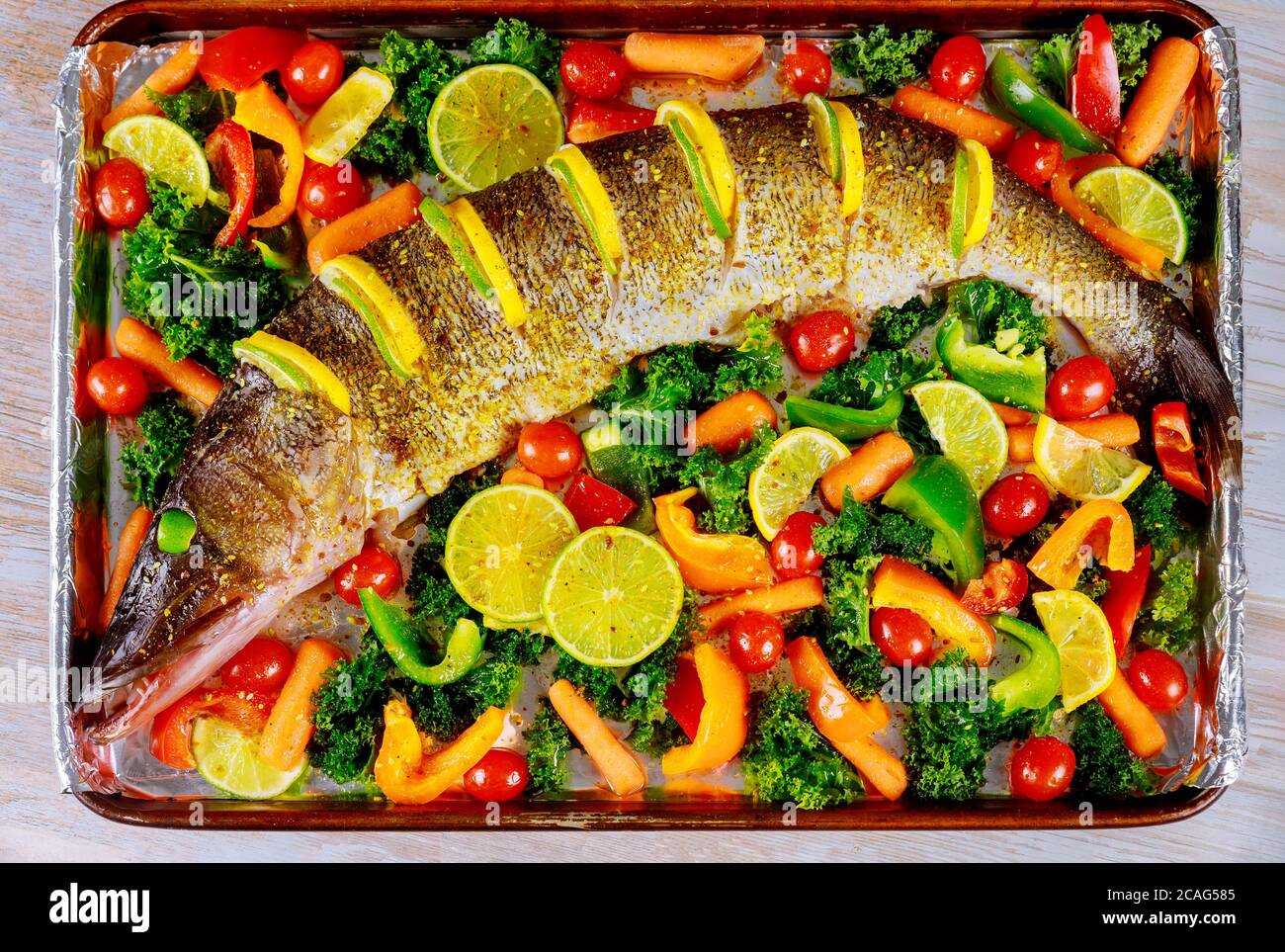 Preparation raw pike fish with vegetable for baking in oven tray Stock ...