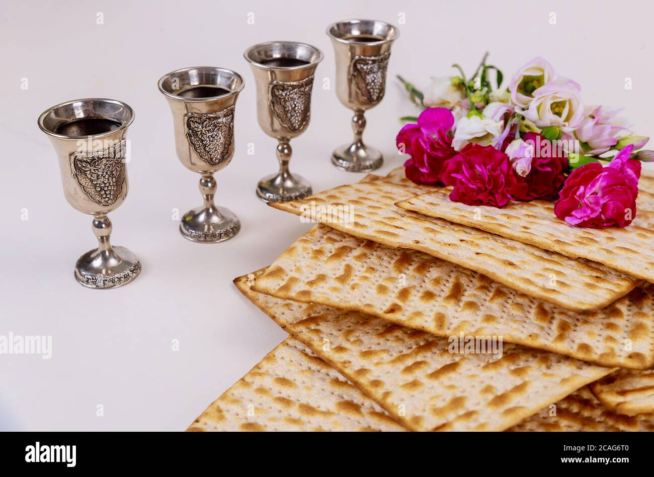 Jewish matzah bread on wooden rustic background with four wine cups and ...