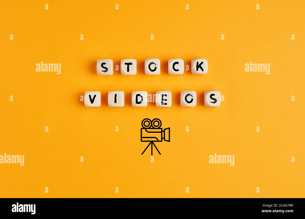 The words stock videos on wooden cubes with camera icon against yellow background. Stock phorography or phoro library concept. Stock Photo