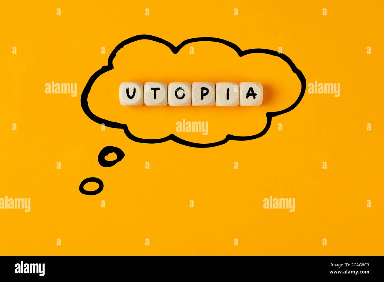 The word utopia written on wooden cubes framed with a thought bubble. Concept of thinking or dreaming of an utopia. Stock Photo