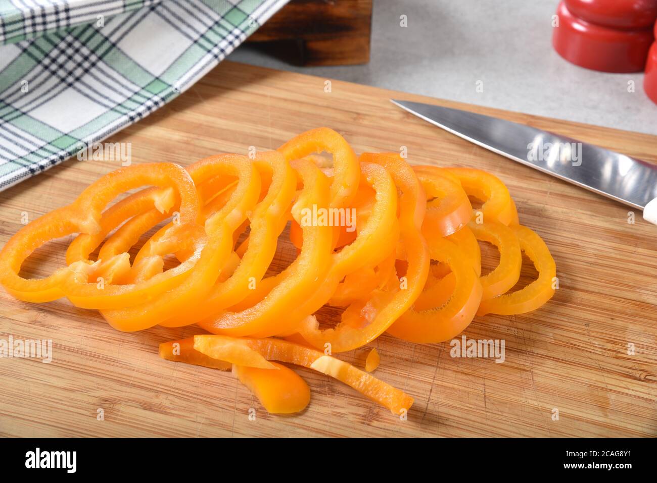 Thin sliced orange bellpeppers on a cutting board. Stock Photo