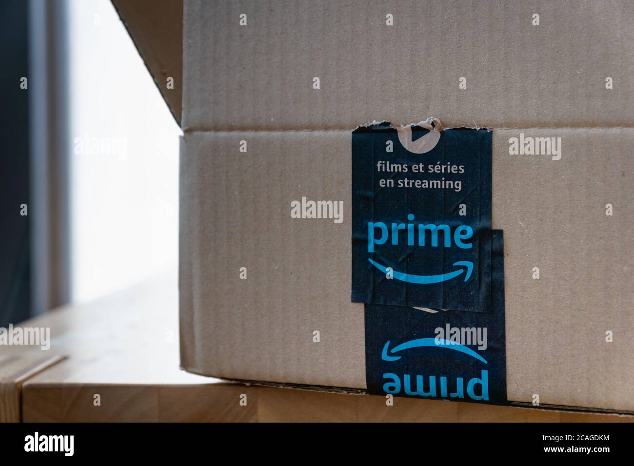 Amazon standard shipping box in EU with Amazon Prime logo scotch tape. Amazon.com, Inc., is an American multinational tech company Stock Photo