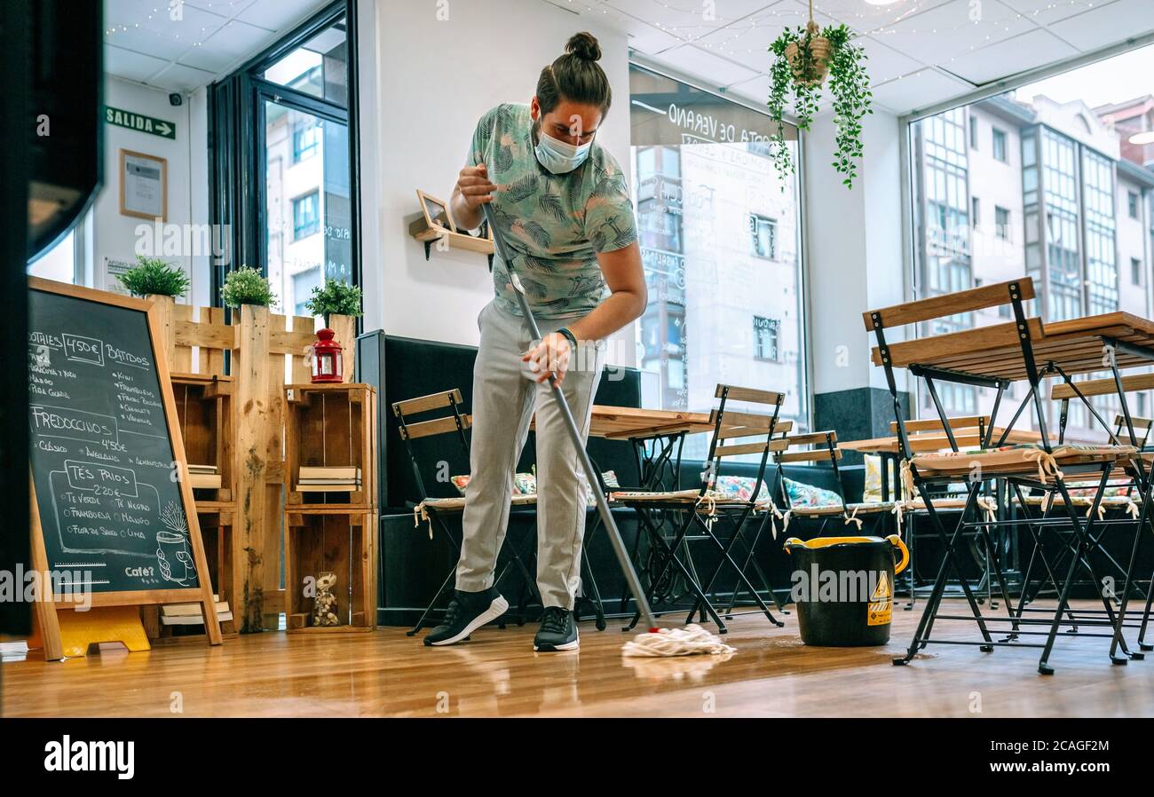 Worker mopping the floor of a restaurant Stock Photo