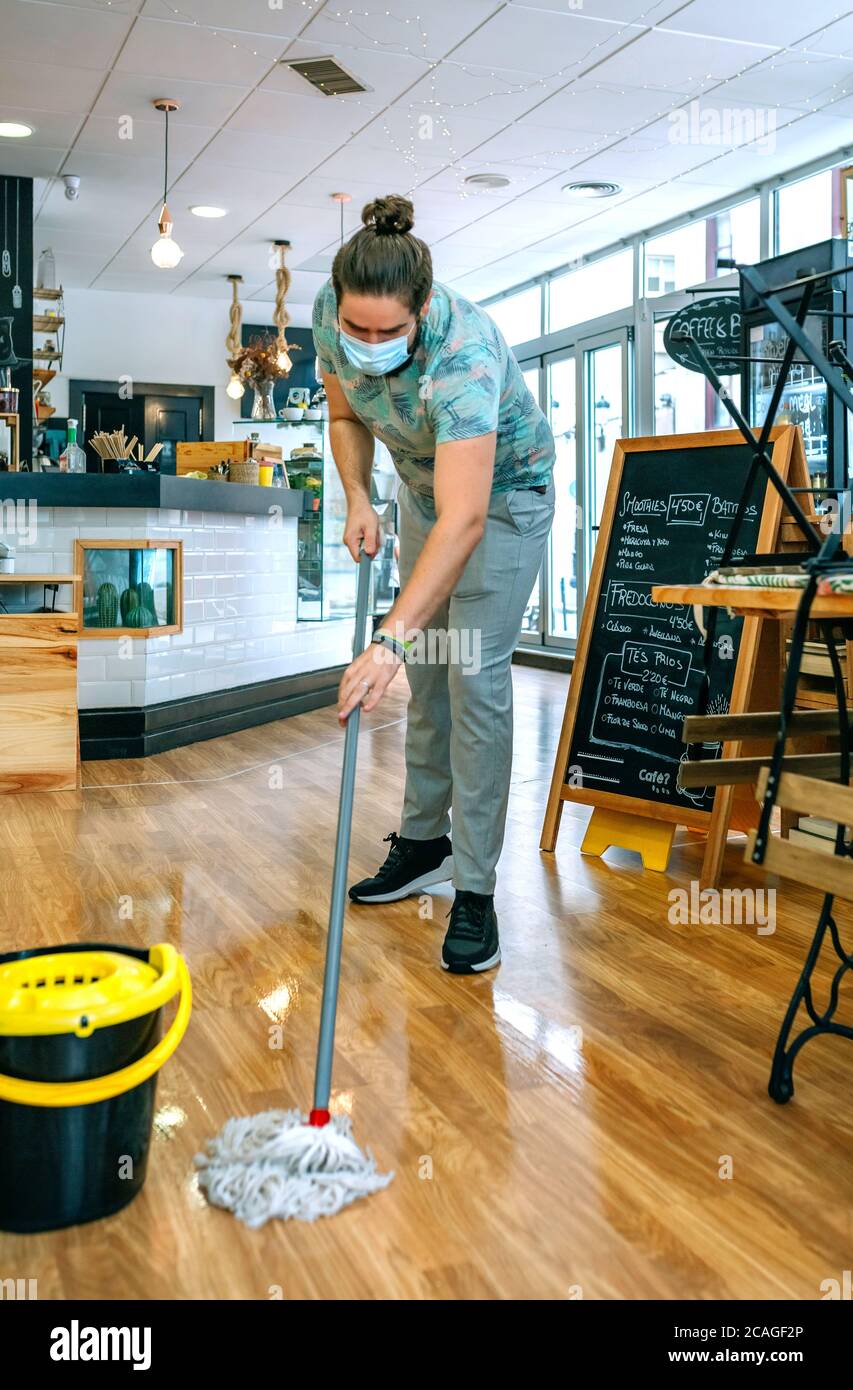 Worker mopping the floor of a coffee shop Stock Photo