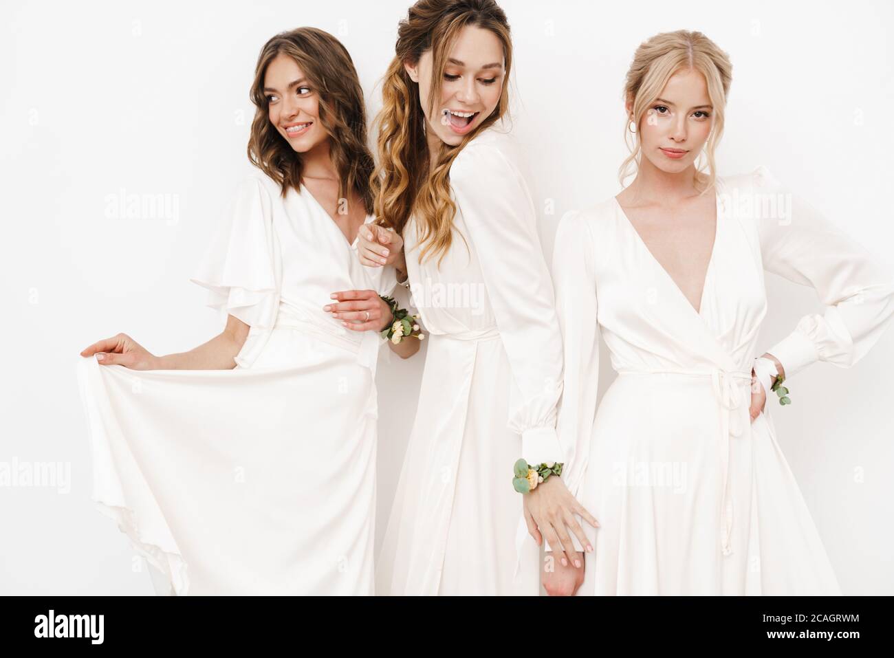 Photo of pleased beautiful bridesmaids in dresses posing on camera ...