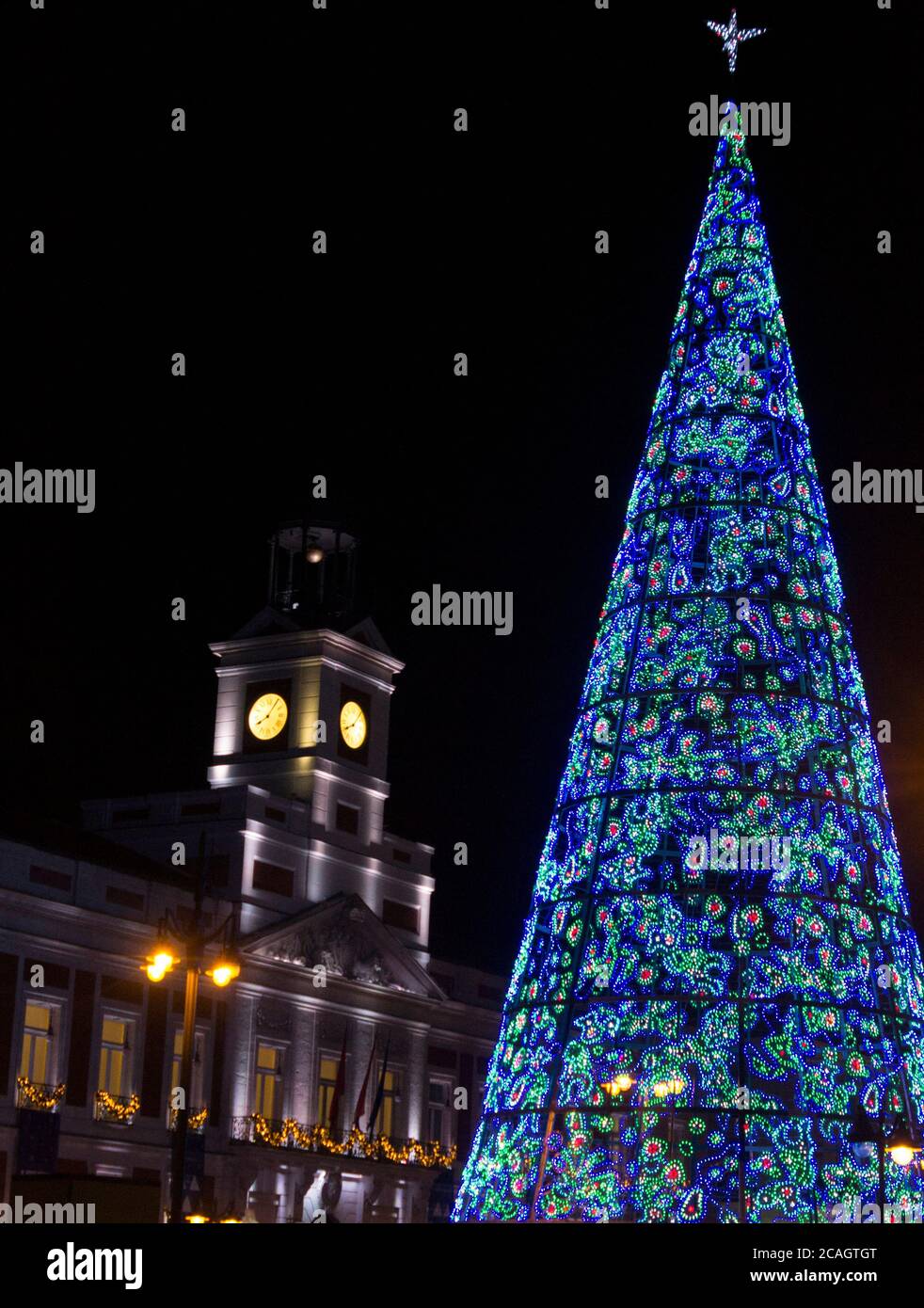 Christmas tree in the center of Madrid. Typical end of the year lights and colors. We can see the Puerta del Sol, the place where the New Year is cele Stock Photo