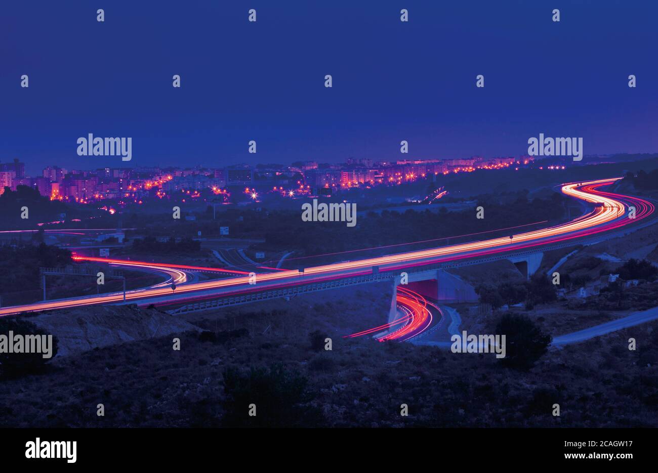 Torremolinos, Malaga Province, Costa del Sol, Andalusia, southern Spain.  Vehicle headlight trails at dusk on the E-15/A-7 highway, the Autovia del Me Stock Photo