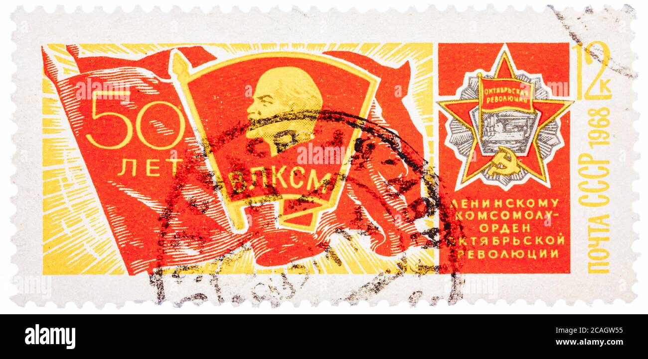 Stamp printed in USSR, shows banner of komsomol with badge and Order of October Revolution, devoted to the 50-th anniversary of komsomol Stock Photo