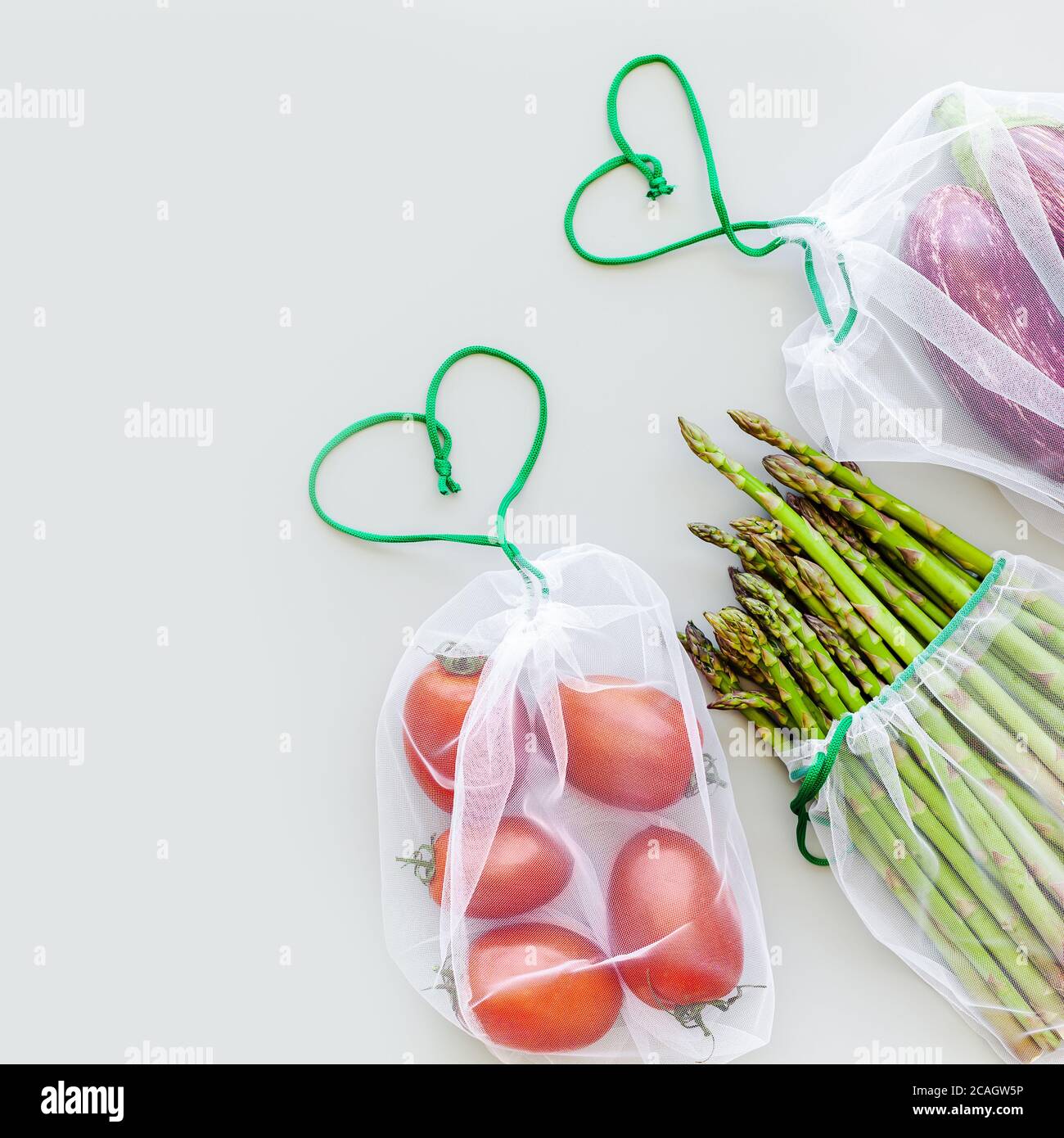 Fresh organic vegetables in eco reusable produce shopping bags flat lay ...