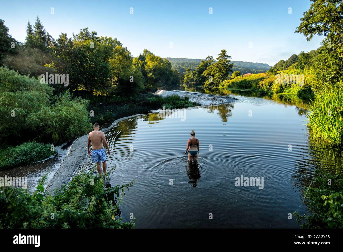 People enjoy an early morning swim at Warleigh Weir on the River Avon near Bath in Somerset as temperatures are set soar across the United Kingdom. Stock Photo