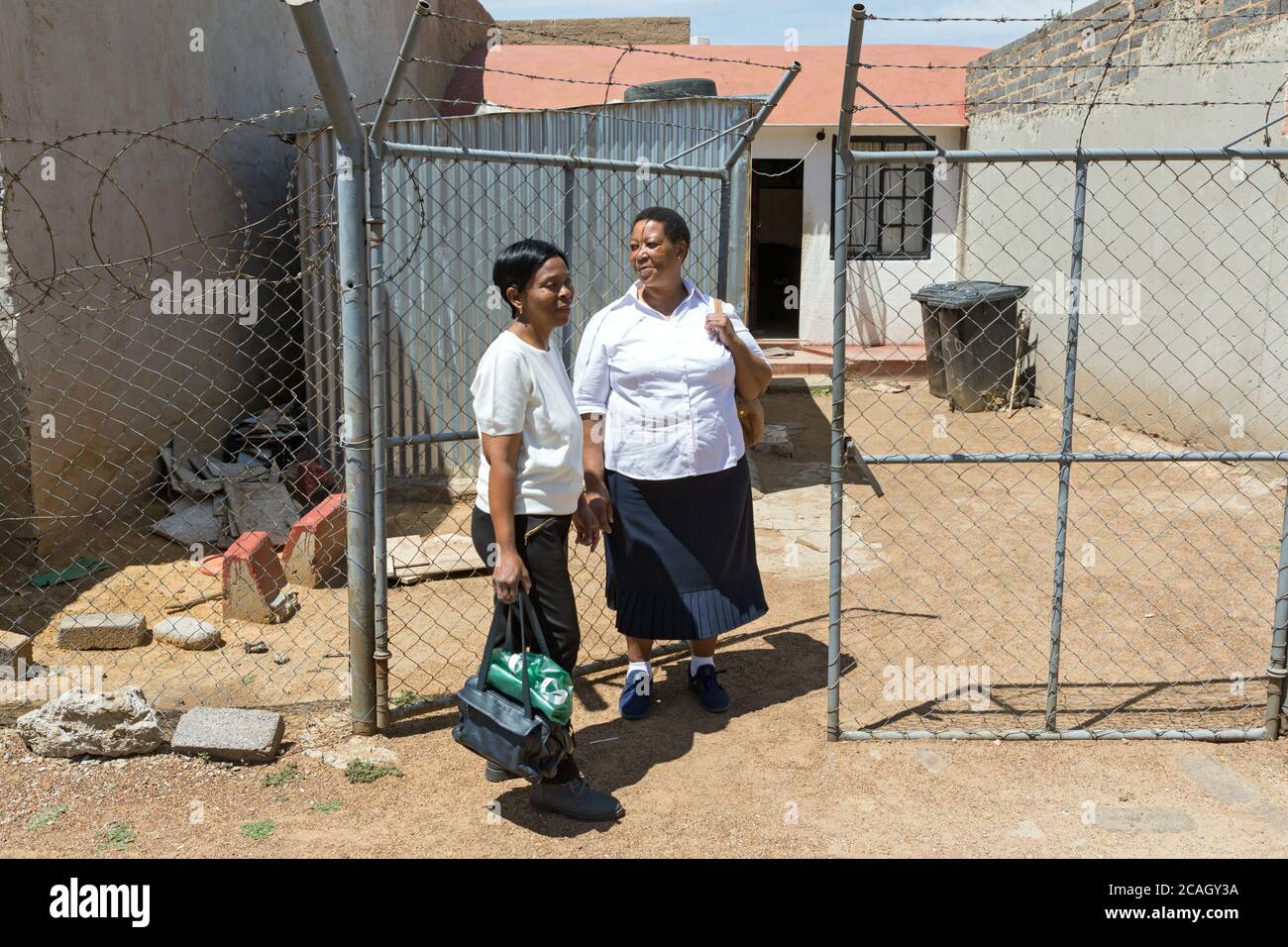 22.10.2018, Johannesburg, Gauteng, South Africa - Nursing staff of a home care service are standing in front of the entrance gate of a house. The gate Stock Photo