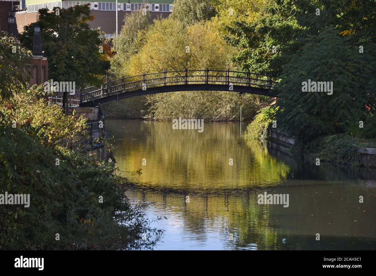 An arched bridge reflected in the still waters of the river Kennet in the centre of Reading, Berkshire Stock Photo