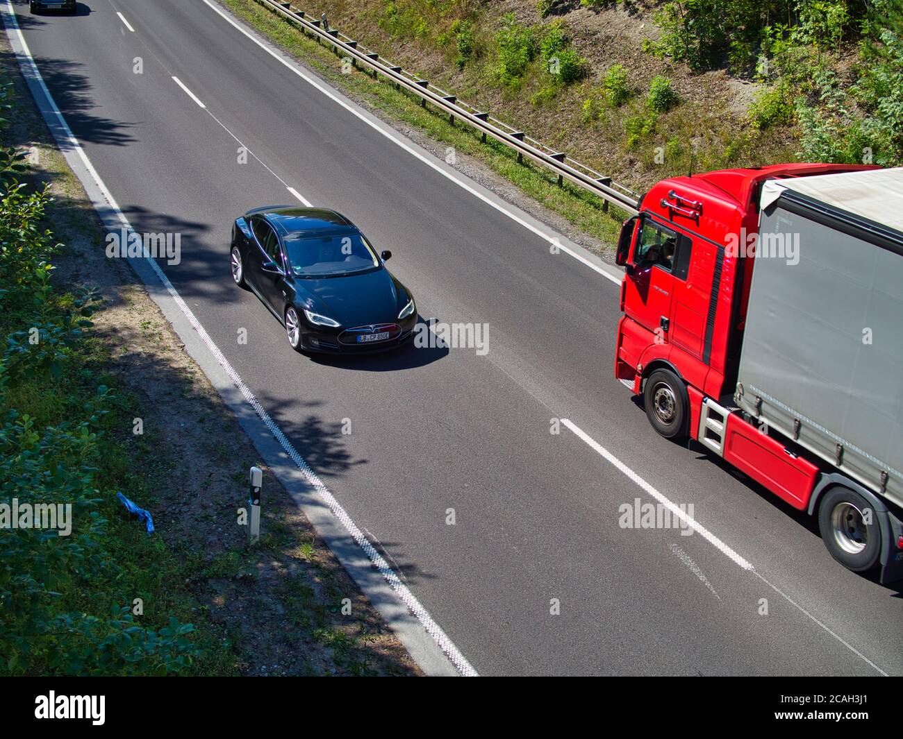 Der Blick auf die Bundesstraße B27 in Stuttgart. Ein Tesla Model S und ein LKW am fahren. Stock Photo