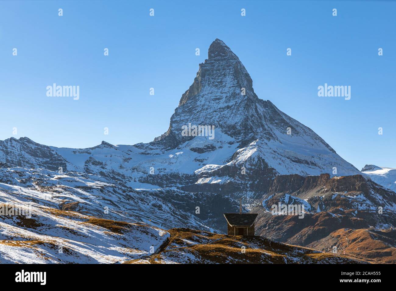 Stunning panorama view of the famous Matterhorn peak of Swiss Alps on sunny autumn day with snow and blue sky, from the train staion Riffelberg with c Stock Photo