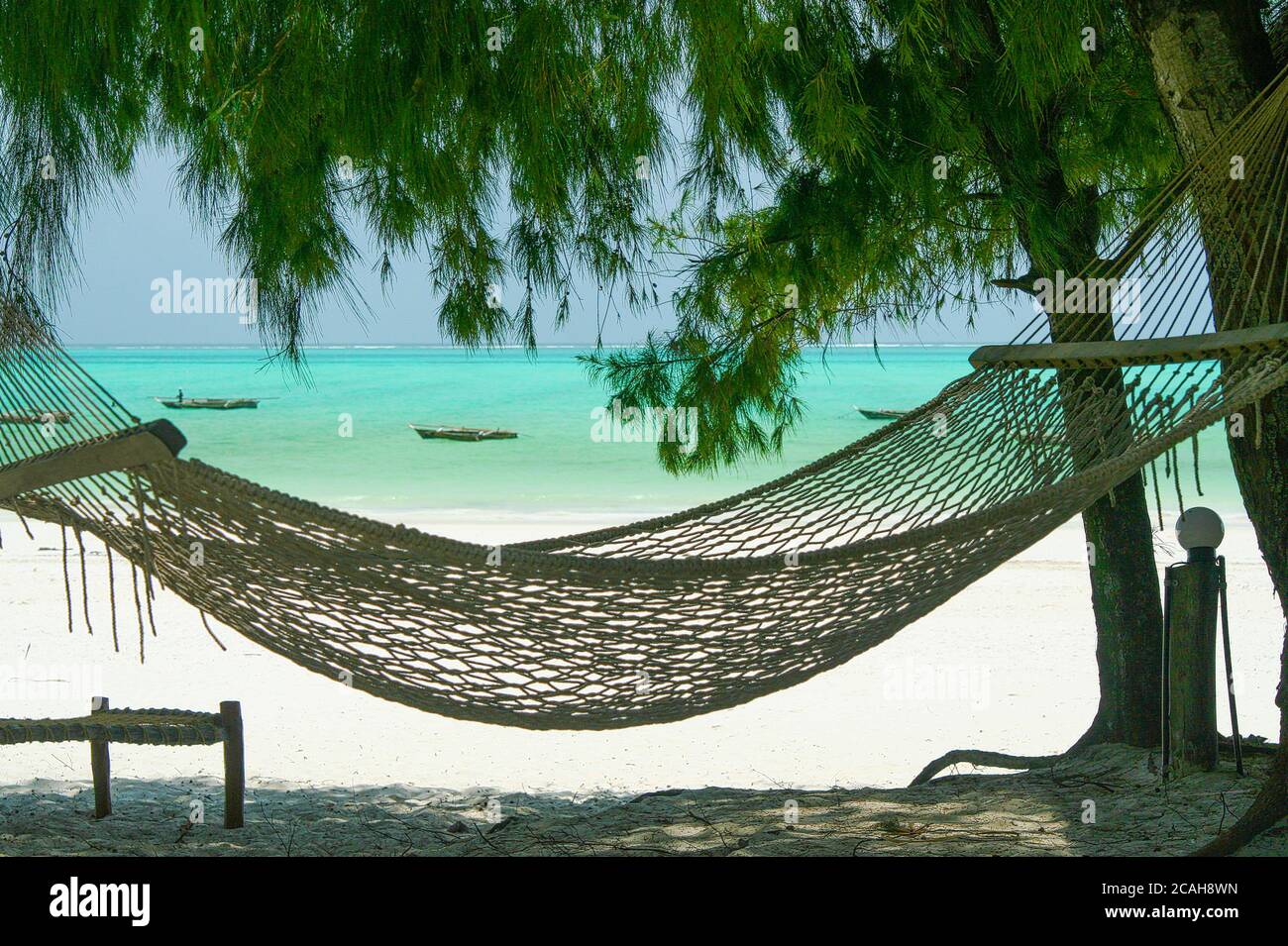 Isolated braided empty beach hammock hanging in shade on trees in caribbean  sea island. Tropical summer vibes and mood. Turquoise sea, white sand, blu  Stock Photo - Alamy