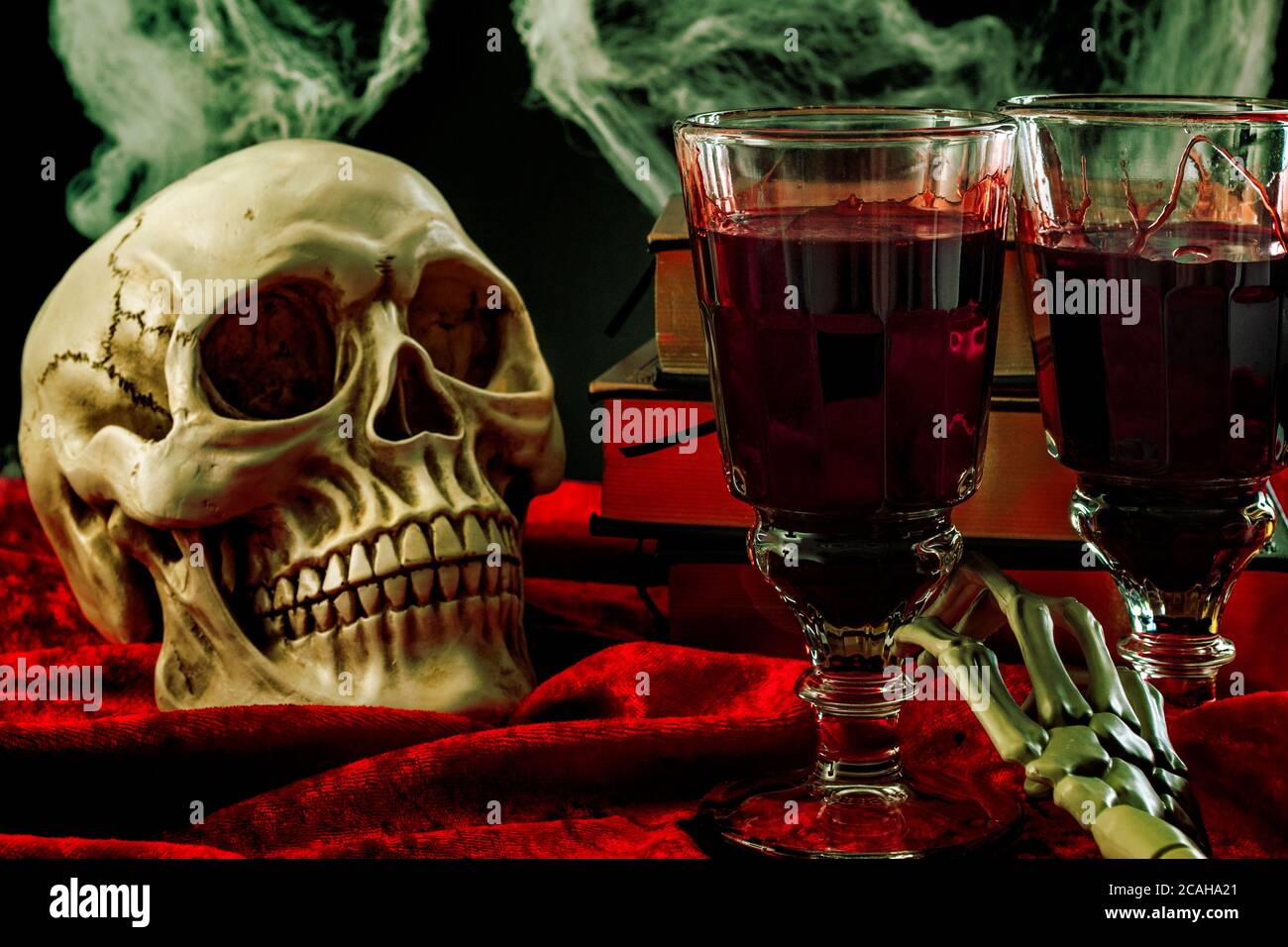 https://c8.alamy.com/comp/2CAHA21/halloween-backdrop-haunted-house-and-vampire-drink-conceptual-idea-with-skull-glass-filled-with-blood-spiderwebs-vintage-books-and-skeleton-arm-on-2CAHA21.jpg