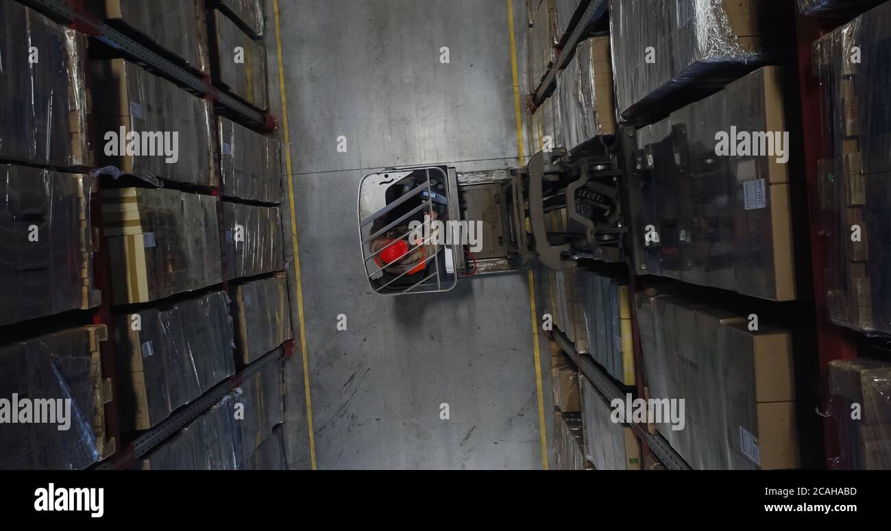 warehouse worker driver in uniform loading cardboard boxes by forklift ...