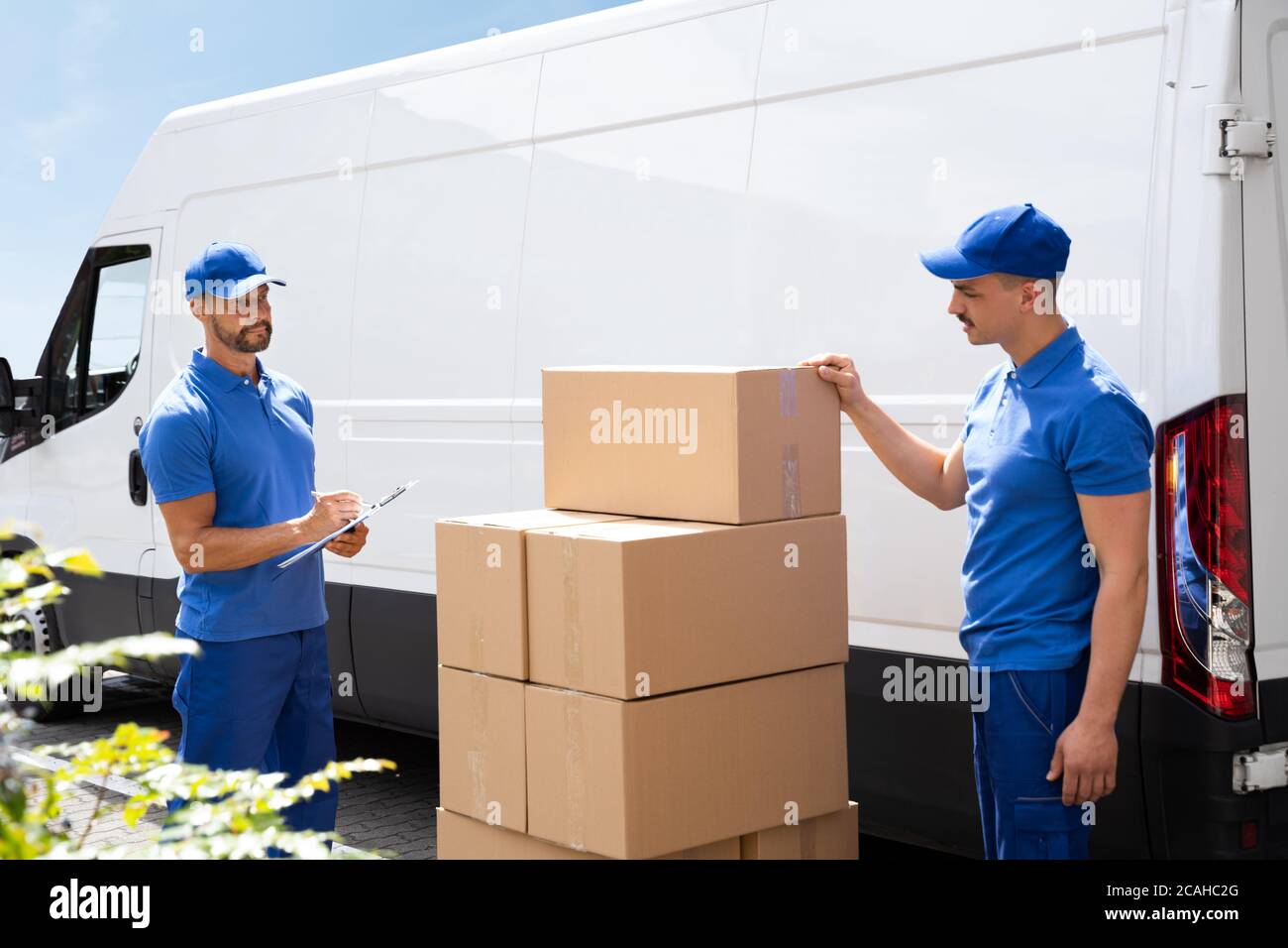 Van Courier And Professional Movers Unload Truck Stock Photo Alamy