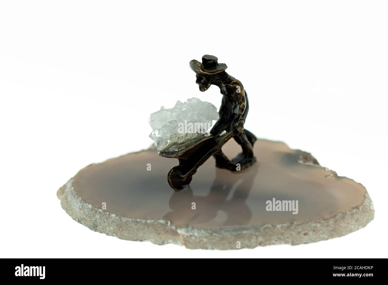Isolated small metal miner figurine on a stone Stock Photo