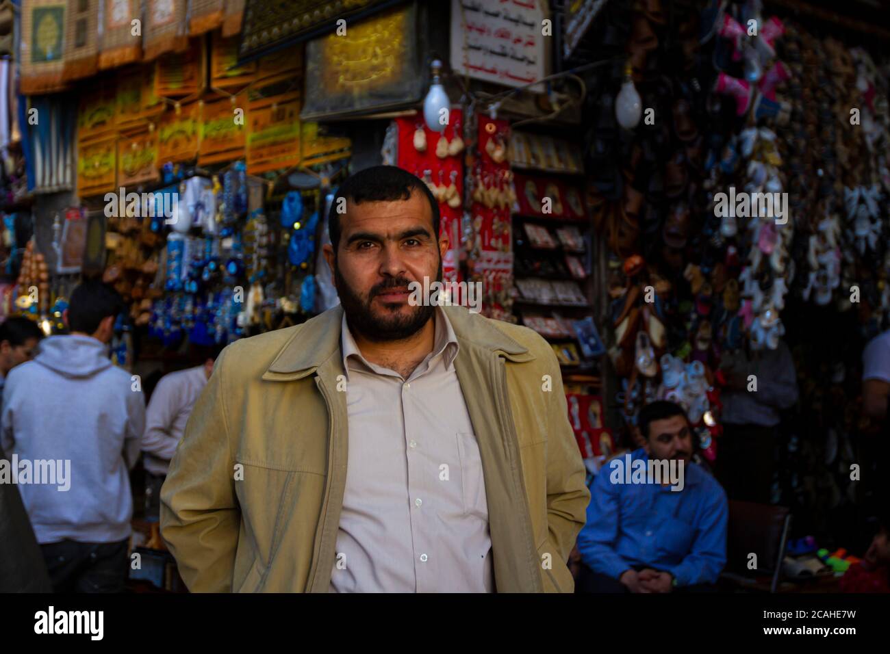 Damascus, Syria 03/28/2010: Selective focus portrait of a bearded Syrian shopkeeper in Al Hamidiyah Souq as he stands in front of  displays of shops s Stock Photo