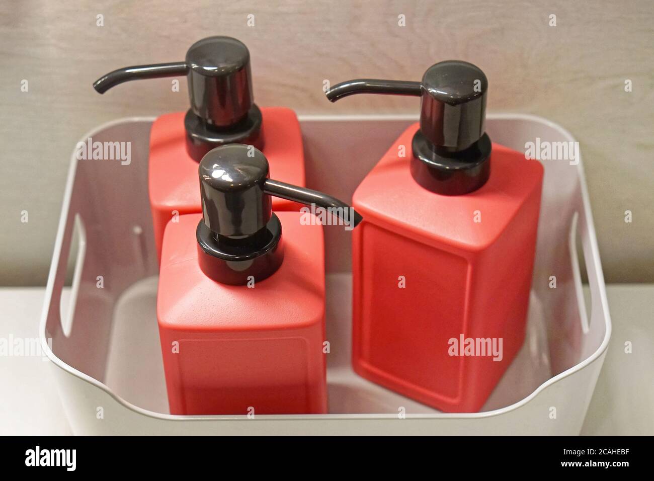Three modern bathroom soap dispensers in crate Stock Photo Alamy