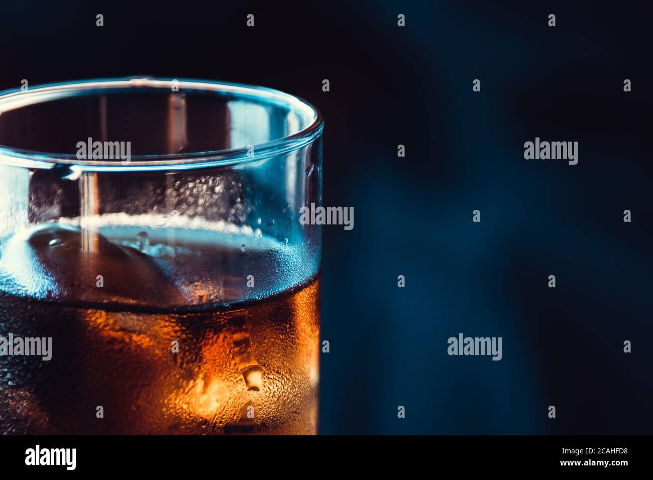 Glass of alcohol in close-up with fresh droplets Stock Photo