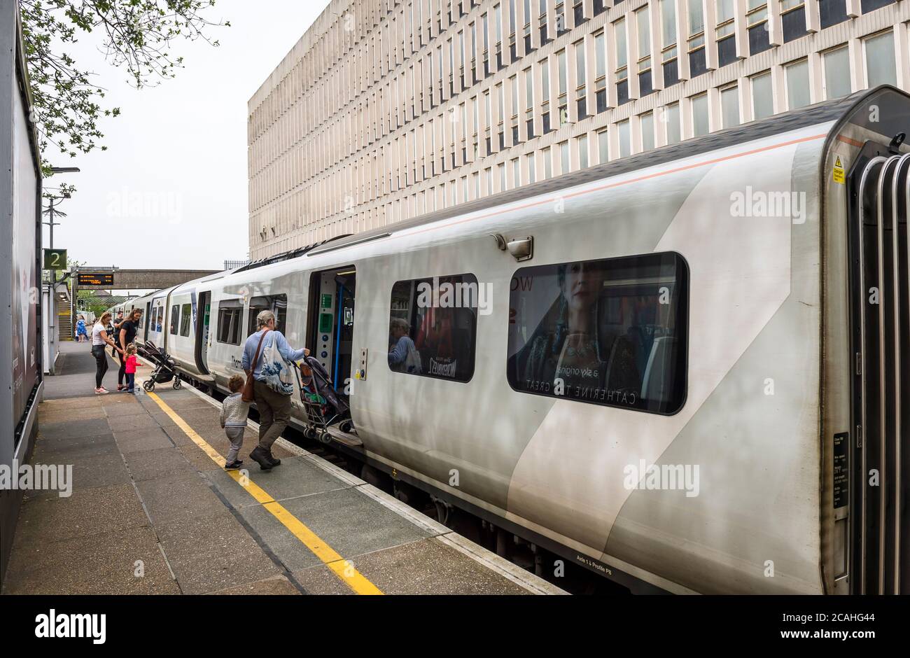 Passengers boarding a class 700 train in Thameslink livery at Crawley
