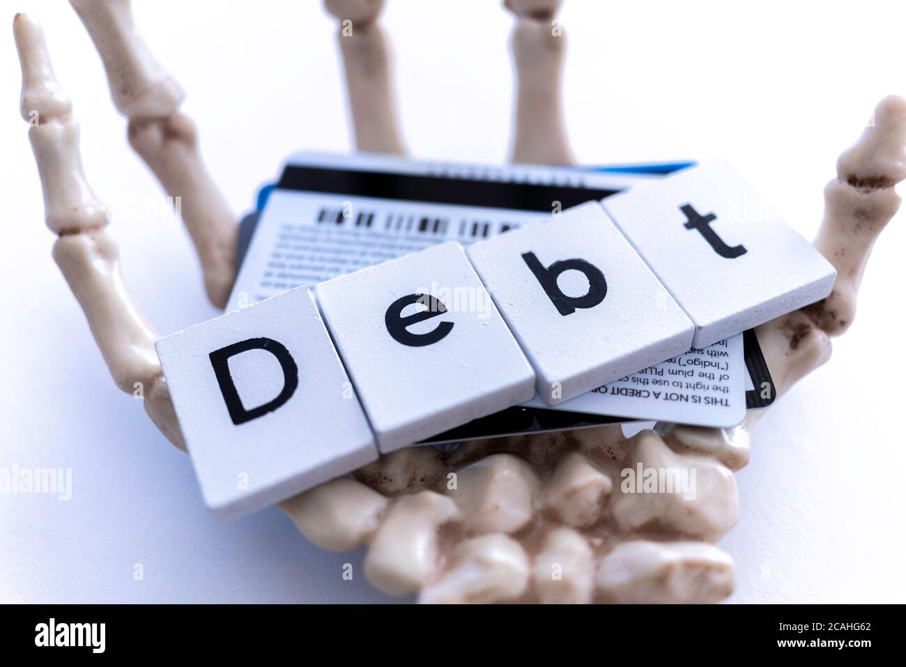 Skeleton hand holding credit cards to illustrate credit card debt Stock Photo