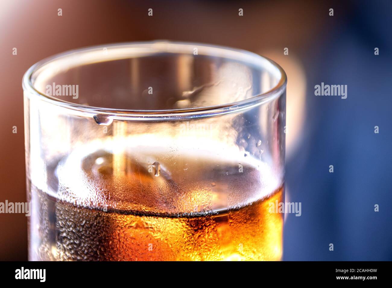 Glass of alcohol in close-up with fresh droplets Stock Photo