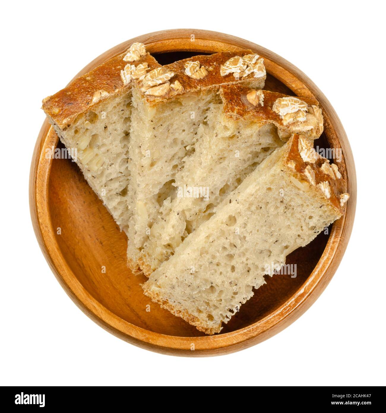 Slices of spelt bread in a wooden bowl. Brown sourdough bread, a mix of spelt flour, leaven, sunflower seeds and spices, baked in an oven. Staple food Stock Photo