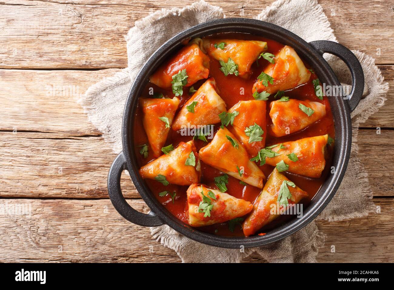 cabbage rolls stuffed with ground beef and rice and baked with a hot tomato sauce close-up in a bowl on the table. Horizontal top view from above Stock Photo