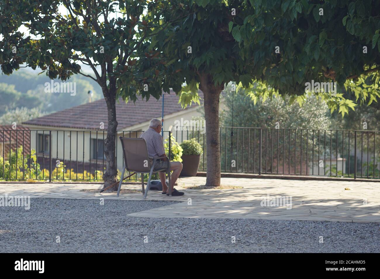 Shot of a lonely old man sitting on a chair in a park Stock Photo - Alamy