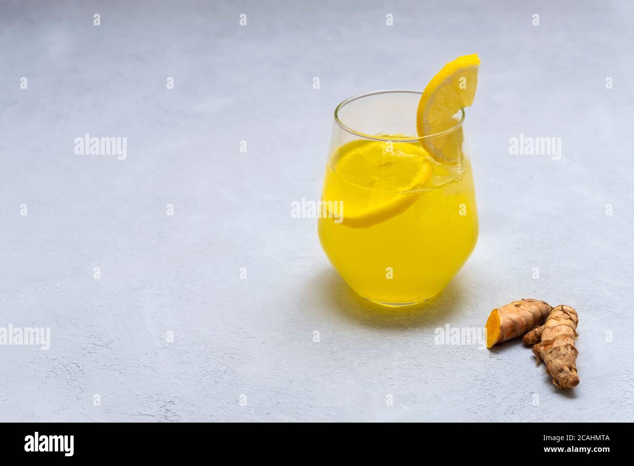 Antiinflammatory turmeric iced tea (lemonade) on neutral grey