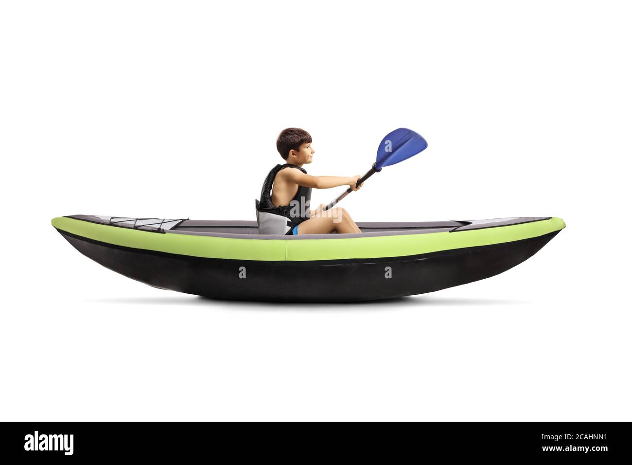 Boy paddling in a green kayak and wearing a safety vest isolated on