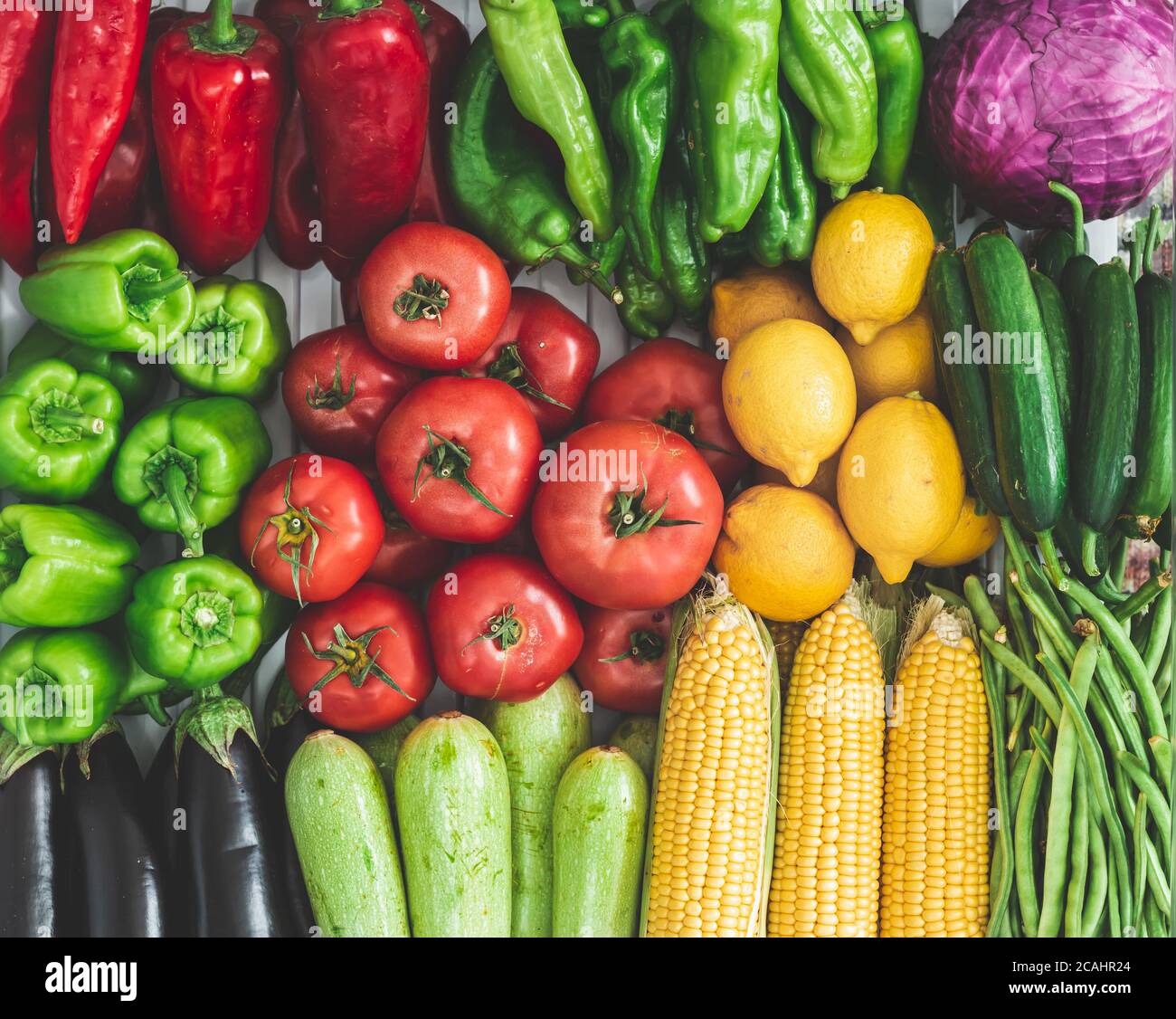 vegetables on the refrigerator shelf, autumn vegetables. full of corn, tomatoes, peppers, zucchini, cabbage, lemon, vegetables. Stock Photo
