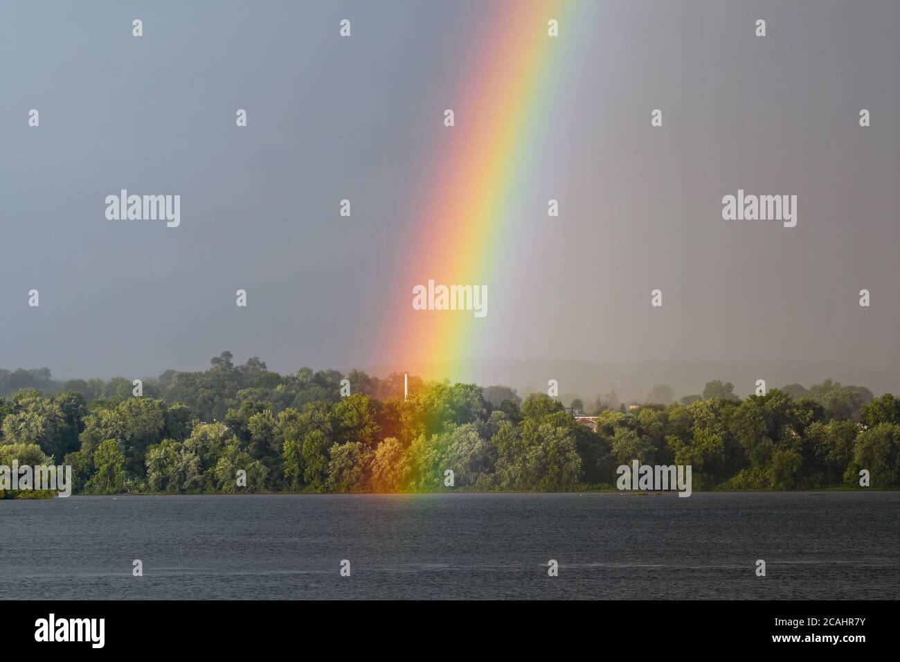 The end of a rainbow during a storm over the Susquehanna River in northeastern USA. Stock Photo