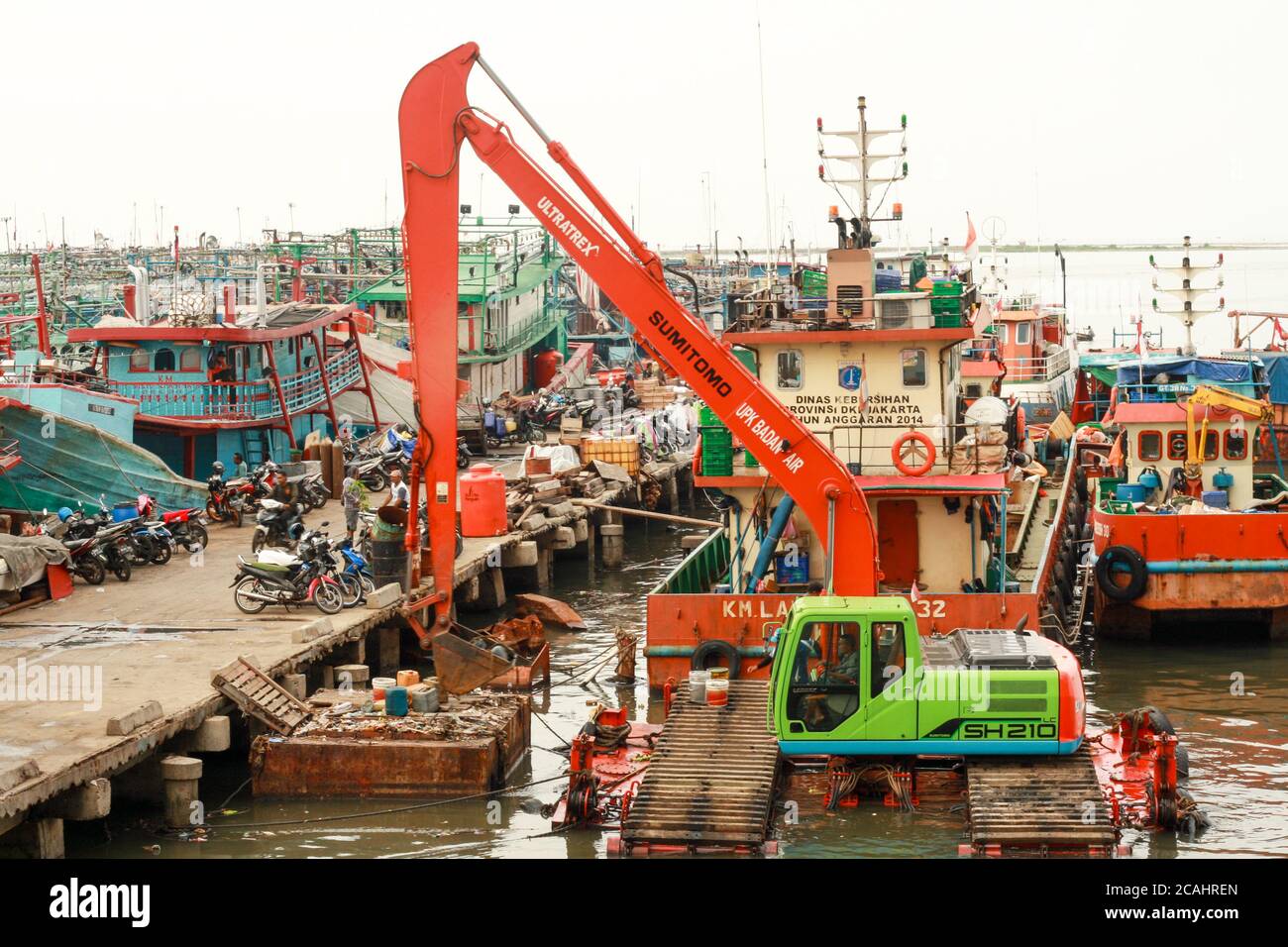 Jakarta, Indonesia - April 21, 2019: An excavator operated to clean up garbage in Muara Angke Port, North Jakarta. Stock Photo