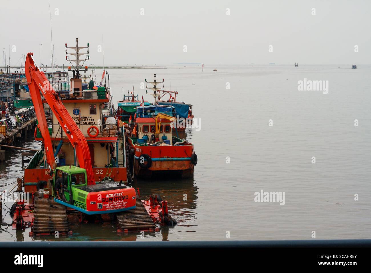 Jakarta, Indonesia - April 21, 2019: An excavator operated to clean up garbage in Muara Angke Port, North Jakarta. Stock Photo