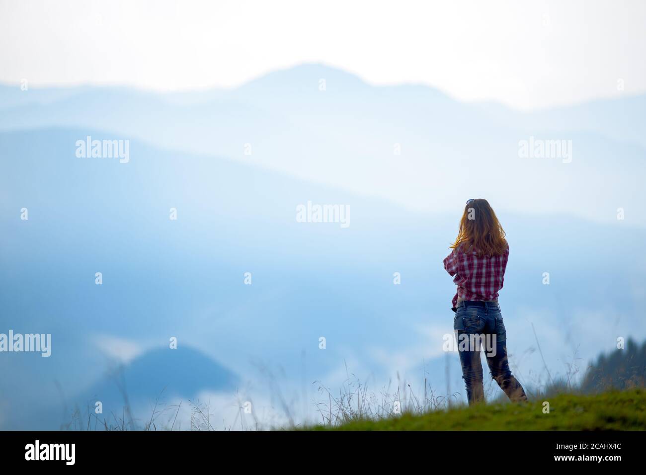 girl tourist high in the mountains sunset sun fog tops of the carpathians Stock Photo